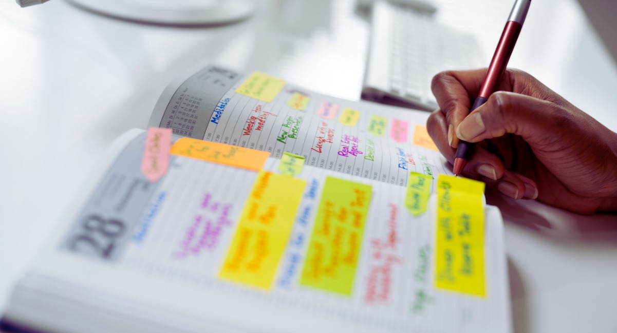 Planification budget séminaire d'entreprise avec agenda et post-its colorés