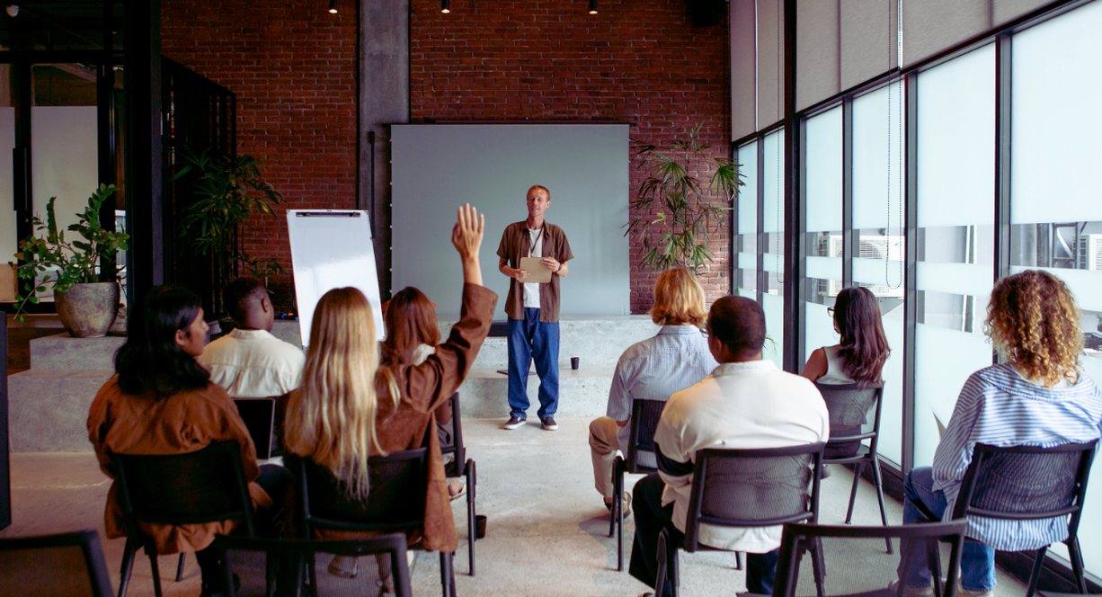 Groupe en séminaire d'entreprise avec animateur présentant le programme