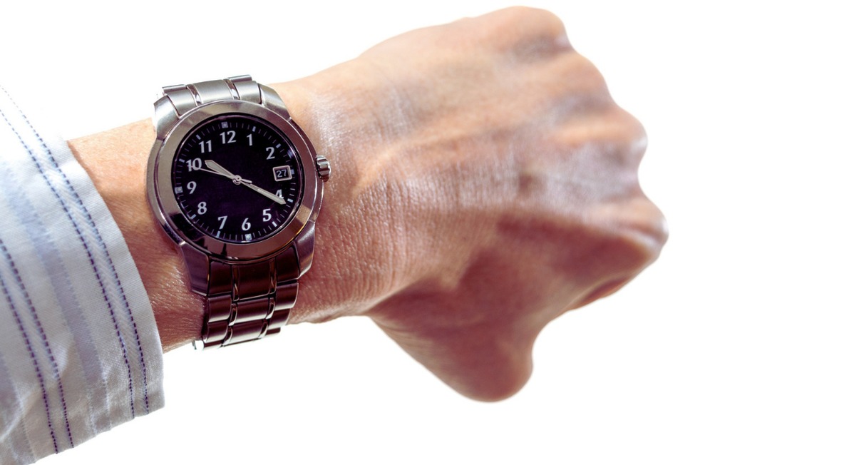 Personne verifiant l'heure a sa montre au poignet